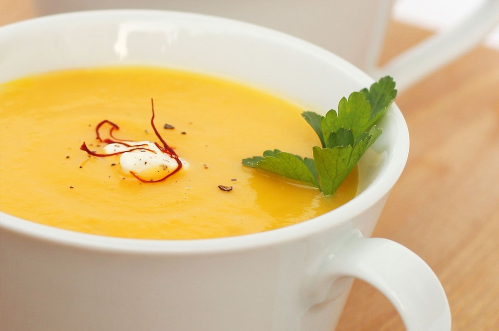 The picture shows a tasty, creamy soup with orange colour